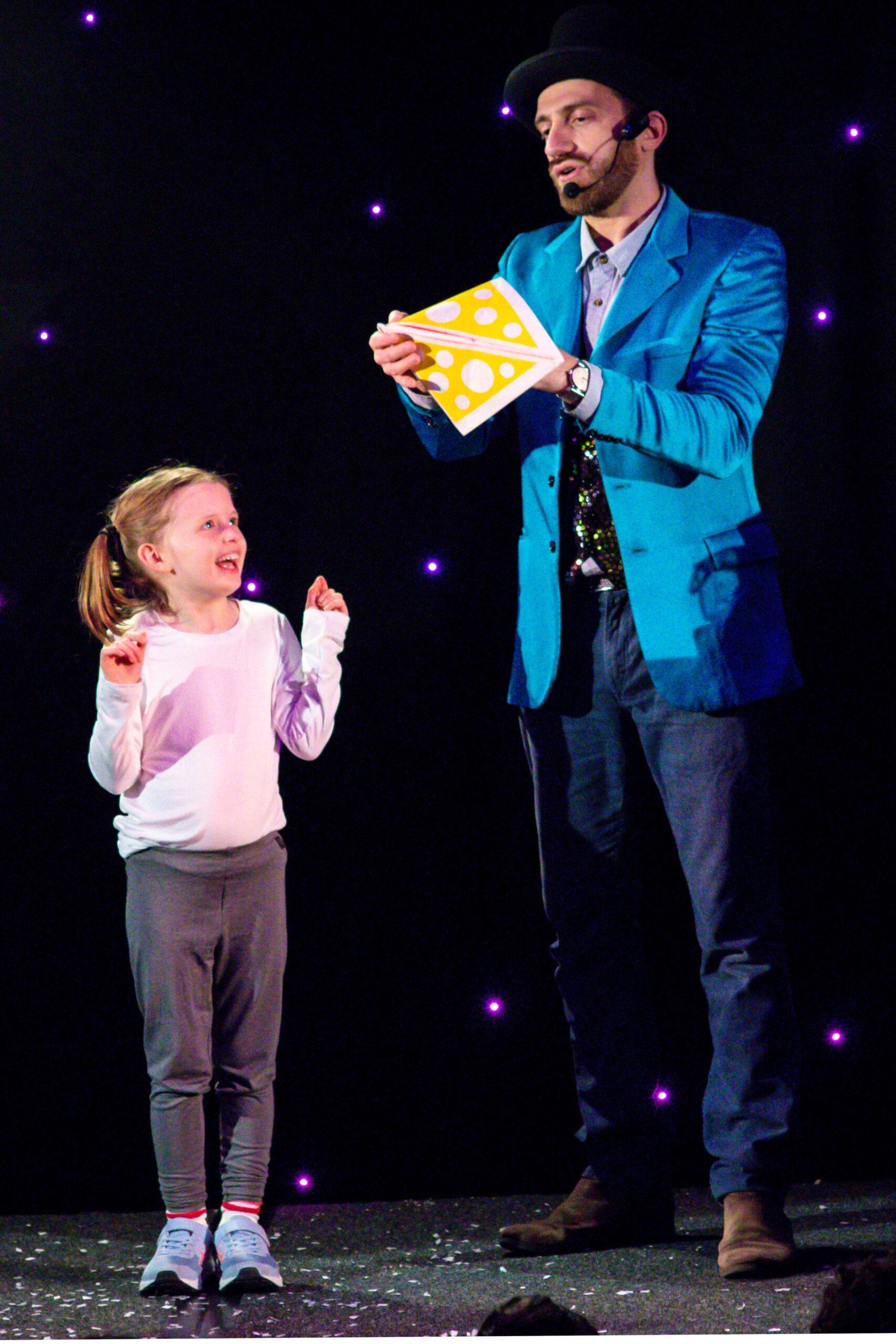 A small children is smiling while being on stage with Armando